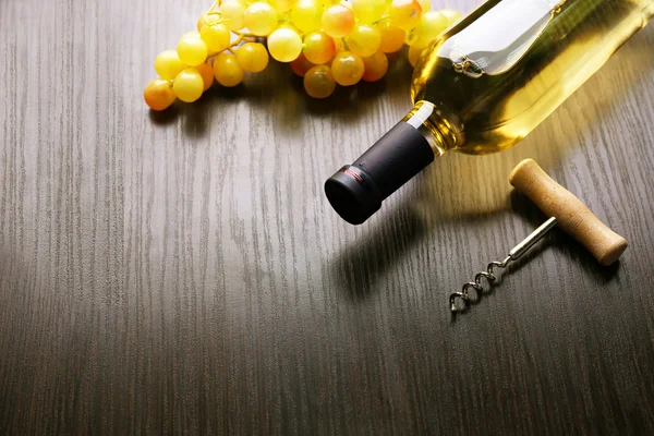 Şişe şarap üzüm ve tirbuşon ahşap arka plan üzerinde — Stok fotoğraf