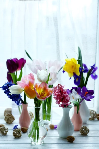 Beautiful bouquets of spring flowers on windowsill background — Stock Photo, Image