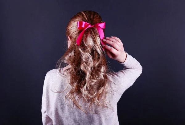 Female hairstyle with color ribbon on dark background — Stock Photo, Image