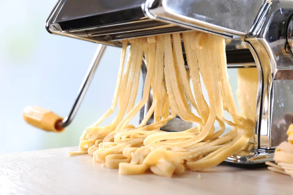 Making noodles with pasta machine on light background — Stock Photo, Image