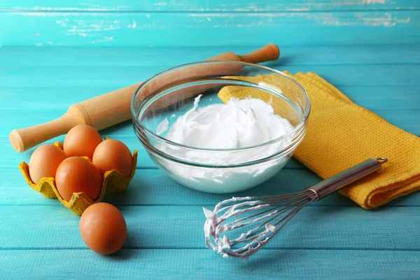 Whipped egg whites for cream on color wooden background — Stock Photo, Image