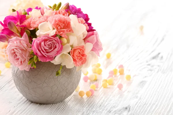 Beautiful fresh spring flowers in pot on wooden table, closeup — Stock Photo, Image