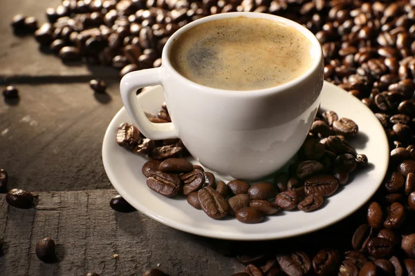 Cup of coffee with grains, closeup — Stock Photo, Image