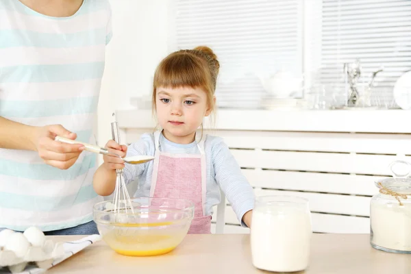 Kleines Mädchen bereitet mit Mutter zu Hause Kekse in Küche zu — Stockfoto