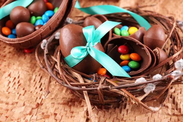 Huevos de Pascua de chocolate en nido de mimbre, primer plano —  Fotos de Stock