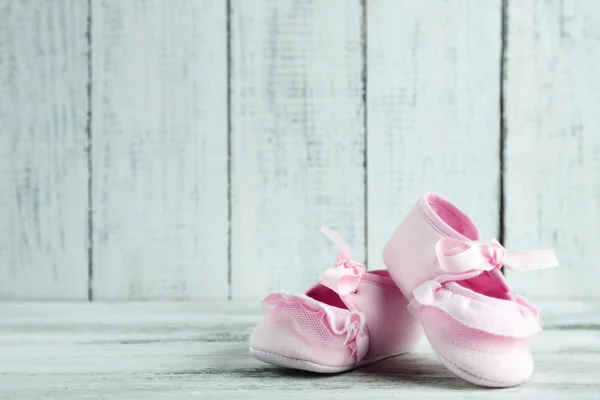 Rosa scarpe bambino su sfondo di legno — Foto Stock