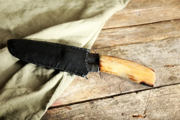 Coltello da caccia e sacco su sfondo di legno — Foto Stock