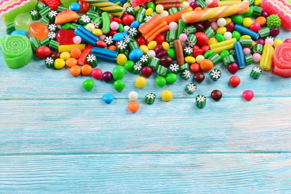 Bunte Bonbons auf hölzernem Hintergrund — Stockfoto