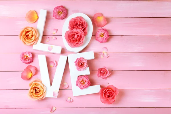 Beautiful roses with word LOVE — Stock Photo, Image