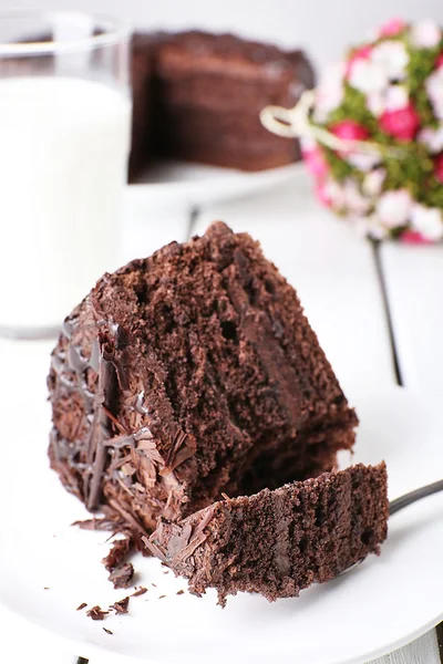 Pastel de chocolate sabroso en rodajas en plato sobre mesa de madera, primer plano — Foto de Stock