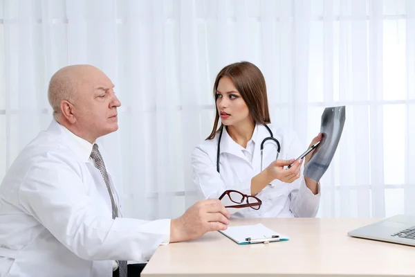 Doctors receiving X-ray results in office on white background — Stock Photo, Image