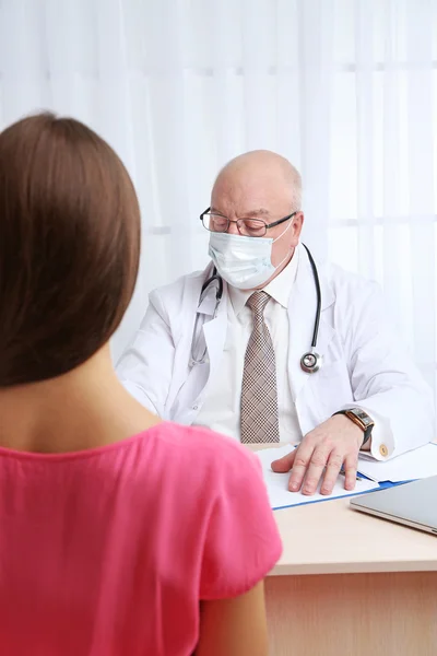 Medico professionista che riceve paziente nel suo ufficio su sfondo tenda bianca — Foto Stock