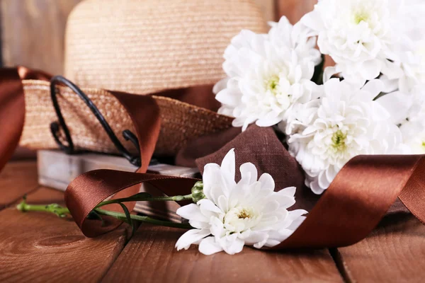 Hut mit Blumen auf Holzgrund, Nahaufnahme — Stockfoto