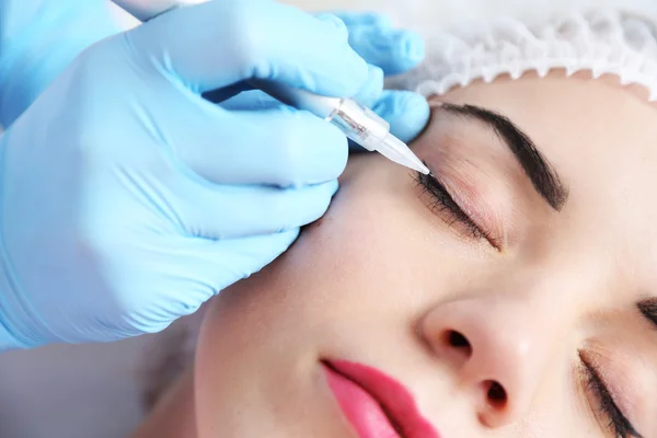 Cosmetologist applying permanent make up