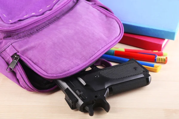 Gun in school backpack — Stock Photo, Image