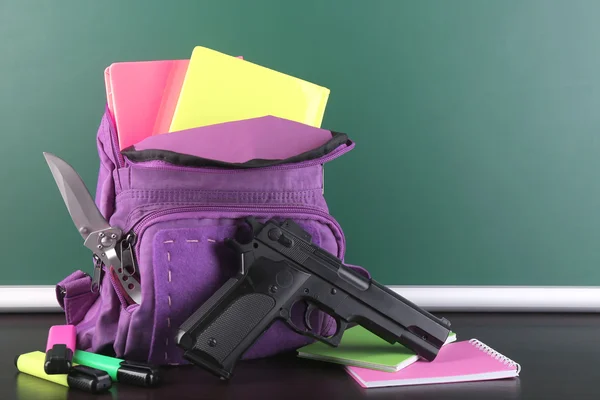 Arma na mochila da escola — Fotografia de Stock