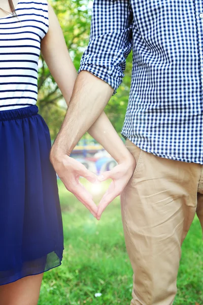 Pareja cariñosa cogida de la mano en forma de corazón, al aire libre —  Fotos de Stock