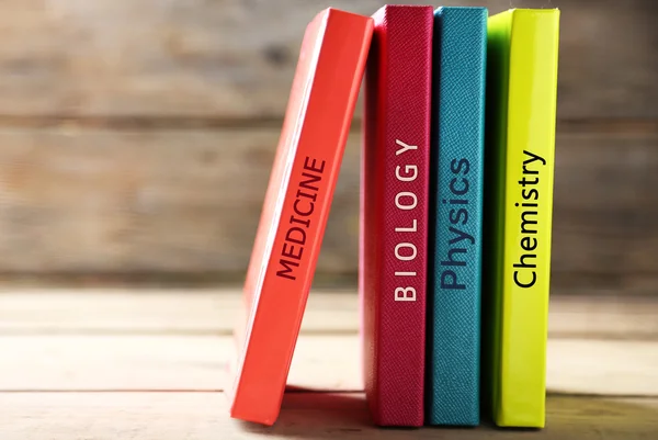 Masada ahşap arka plan üzerinde renkli kitaplar — Stok fotoğraf
