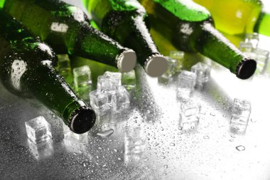 cam şişe bira ıslak tablo arka plan üzerinde buz küpleri ile