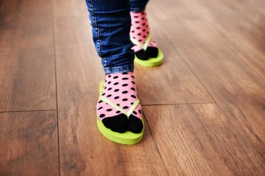 Kat zemin üzerine pembe parmak arası terlik ile çoraplı kadın ayakları