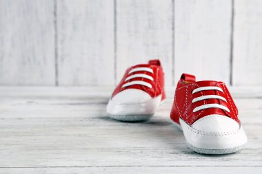 ahşap arka plan üzerinde renkli yürümeye başlayan çocuk ayakkabı