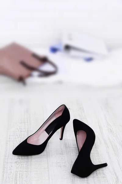 Kvinnliga skor och portföljen på golvet bakgrund — Stockfoto