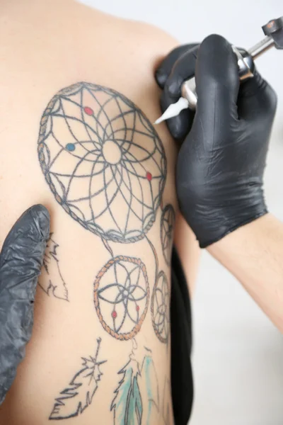 Tattooer showing process of making tattoo, close up — Stock Photo, Image