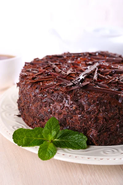 Sabroso pastel de chocolate con taza de té en la mesa de cerca — Foto de Stock