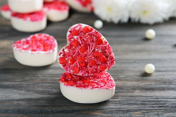 Heerlijke chocolade snoepjes in hart vorm op tabel close-up — Stockfoto