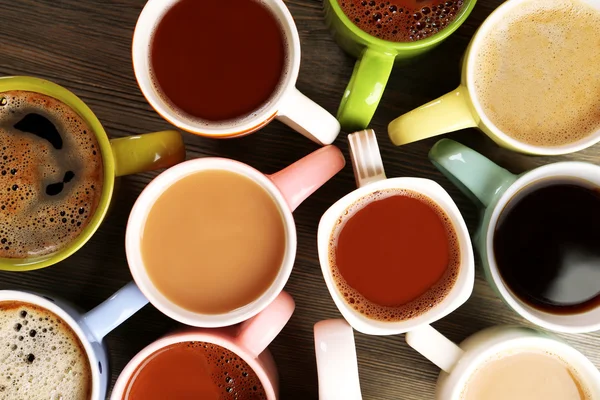 Ahşap masanın üstünde bir sürü kahve fincanı var.