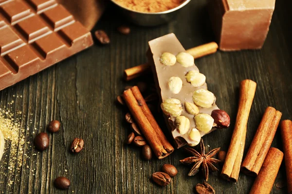 Stilleben med choklad, nötter och kryddor på träbord, närbild — Stockfoto