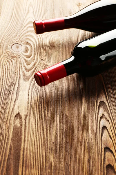 Szklana butelka wina z korkami na drewnianym tle stołu — Zdjęcie stockowe