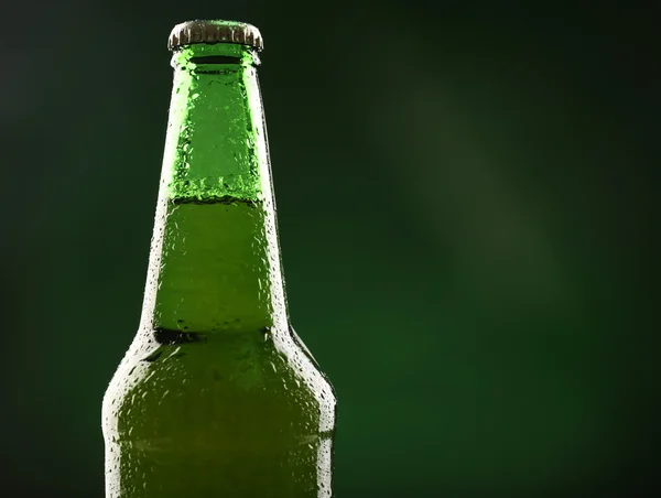 Glazen flesje bier op donkere groene achtergrond — Stockfoto