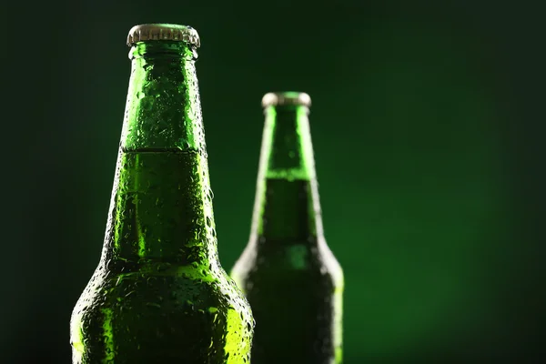 玻璃瓶啤酒上深绿色的背景 — 图库照片