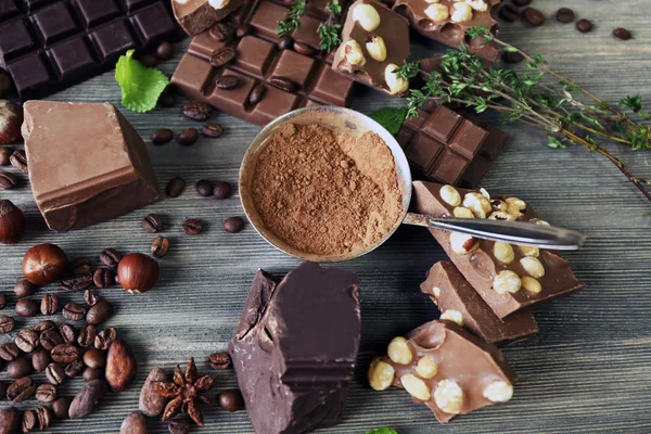 Uppsättning av choklad med nötter, örter och kaffe bönor på träbord, närbild — Stockfoto