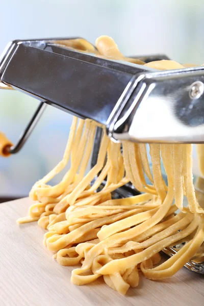 Making noodles with pasta machine on light background — Stock Photo, Image