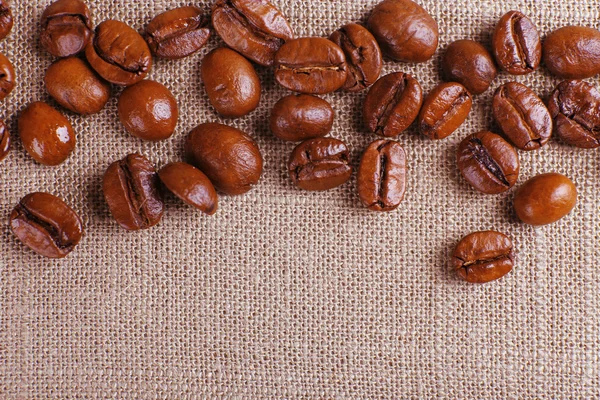 Frame van koffie bonen op zak achtergrondkleur — Stockfoto