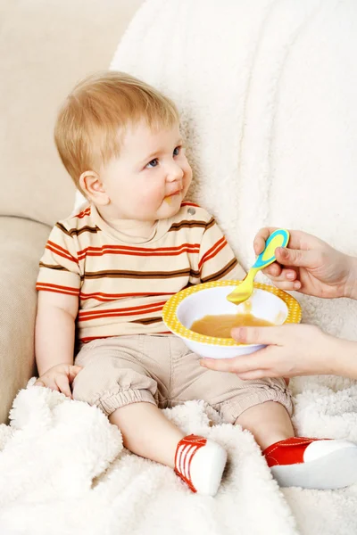 Mãe alimentando seu pequeno filho bonito feliz — Fotografia de Stock