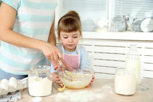 Kleines Mädchen bereitet mit Mutter zu Hause Kekse in Küche zu — Stockfoto