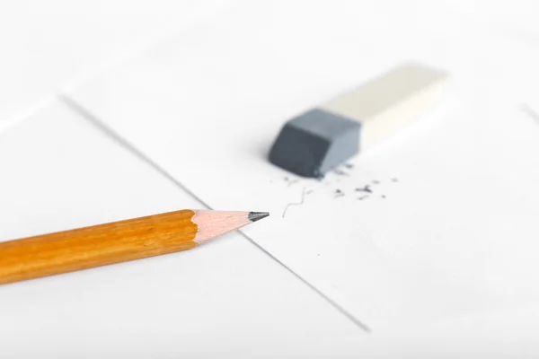 Ластик и карандаш на бумажном фоне — стоковое фото