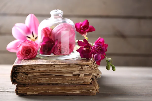 Nádherná skladba s květinami a starých knih o šedé dřevěné pozadí — Stock fotografie