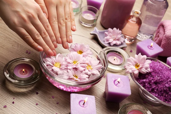 Mãos femininas com tigela de água de spa de aroma em mesa de madeira, close-up — Fotografia de Stock