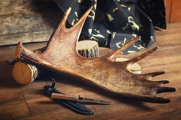 Moose antler with hunting knives on wooden background — Stock Photo, Image