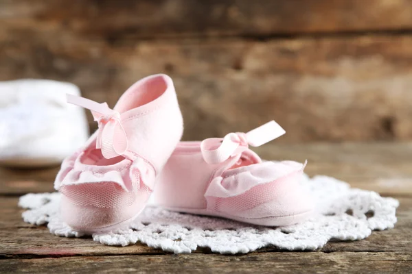 Zapatos de niño rosados sobre fondo de madera — Foto de Stock