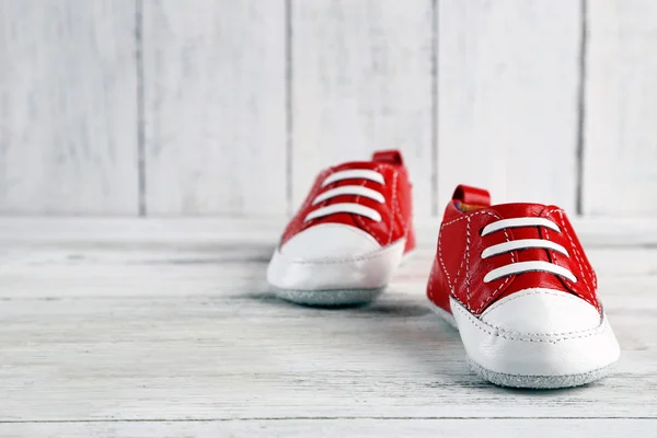 Zapatos coloridos para niños pequeños sobre fondo de madera —  Fotos de Stock