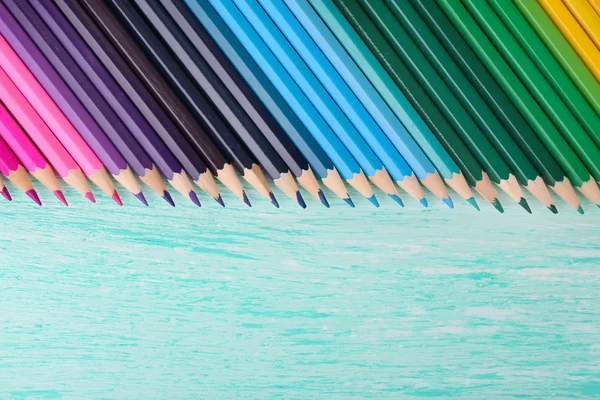 Kolorowe ołówki na drewnianym stole — Zdjęcie stockowe