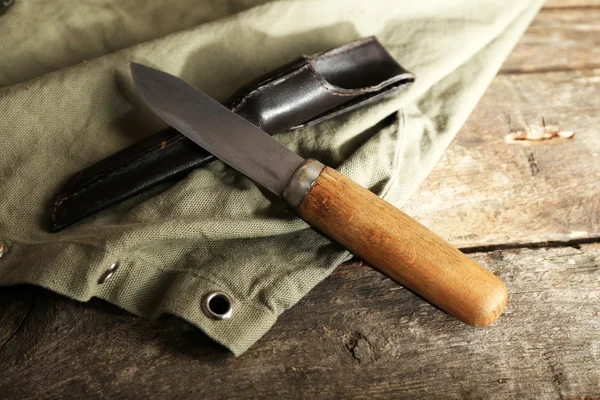 Hunting knife and sackcloth on wooden background — Stock Photo, Image