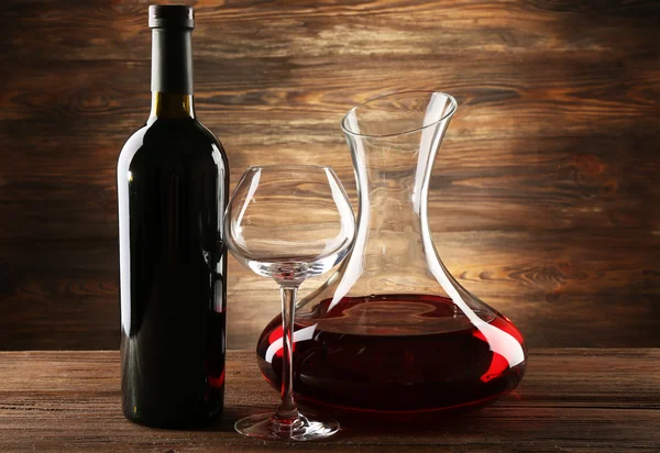 Skleněná karafa vína na dřevěné pozadí — Stock fotografie