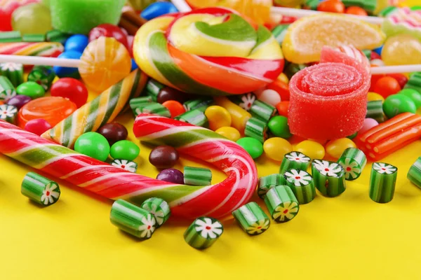 Colorful candies on yellow background — Stock Photo, Image