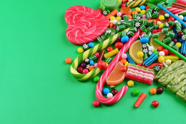 Colorful candies on green background — Stock Photo, Image